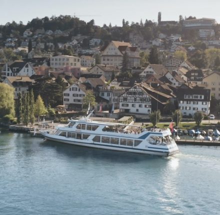 Ein Boot fährt den Fluss inmitten einer Stadt hinunter.